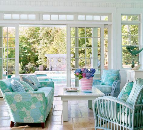 客厅以白色和蓝绿色为主，蓝绿色的花朵布艺沙发确定了客厅的清凉主题，天蓝色的条纹图案和 穿泳装的人物造型起到了点睛效果